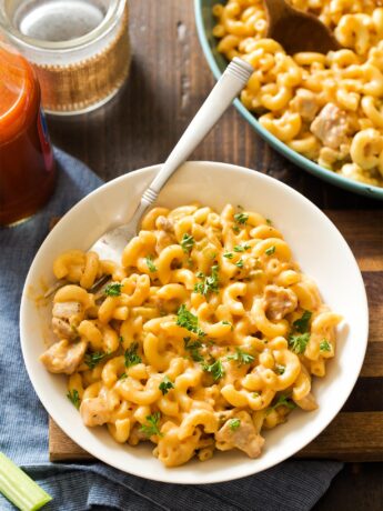 White bowl filled with buffalo chicken mac and cheese with fork