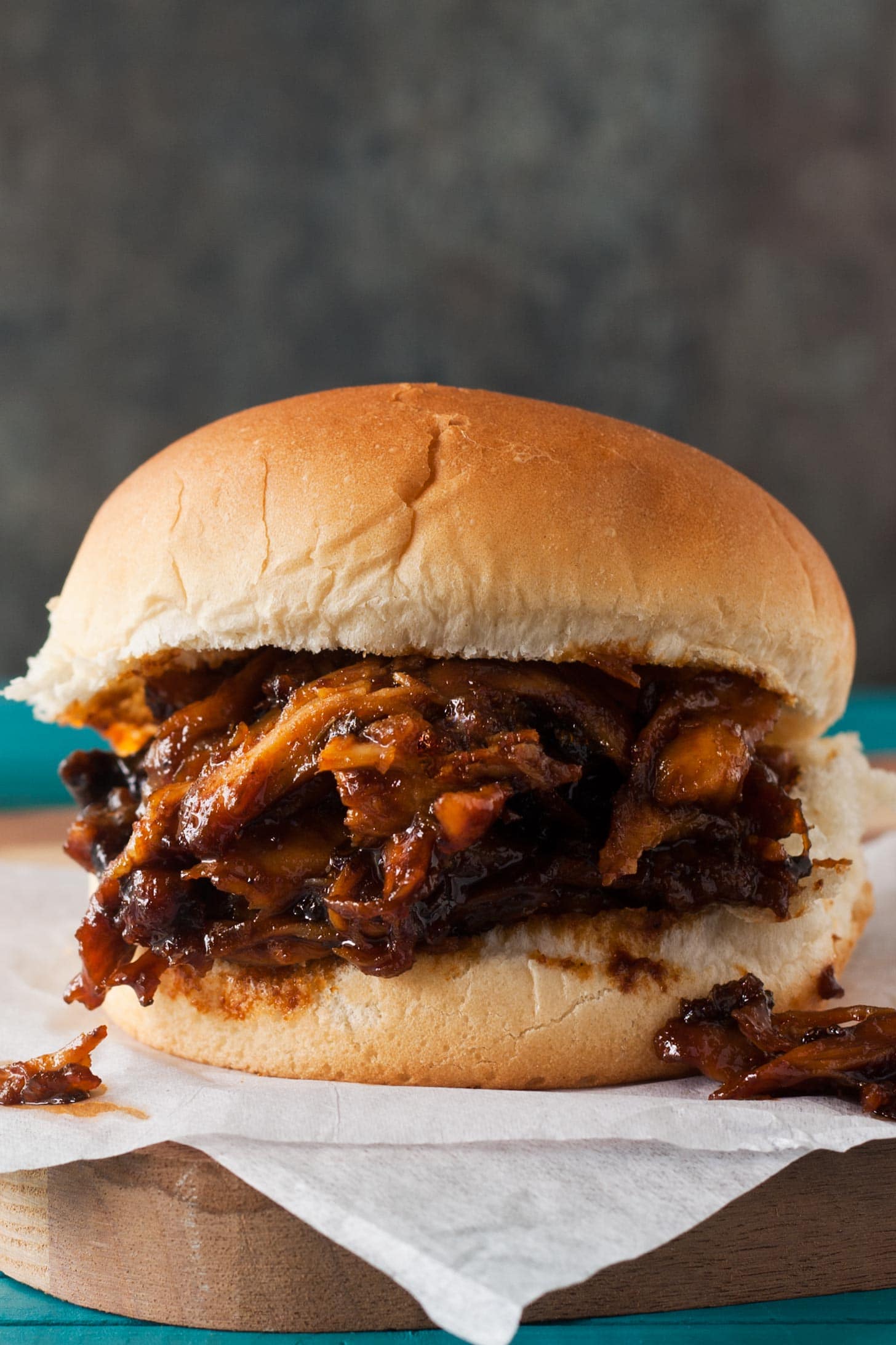Slow Cooker BBQ Pulled Chicken sandwiches on parchment paper