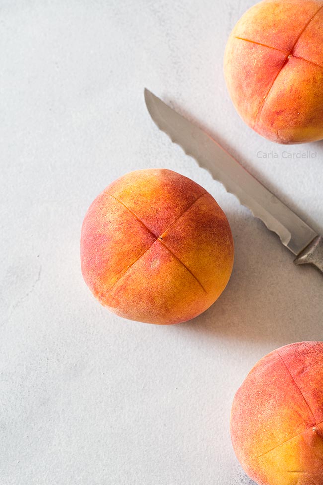 Peaches with an X cut into the bottom