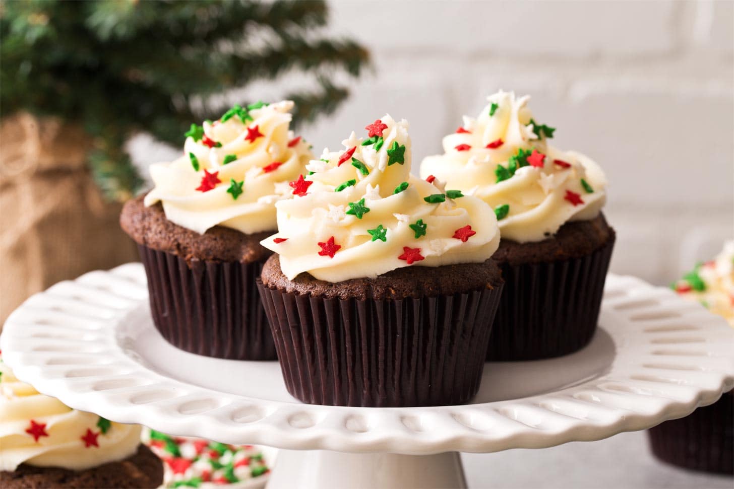 Three gingerbread cupcakes on a cake stand
