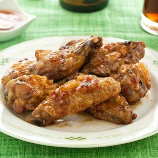 Plate of sweet chili wings on green tablecloth