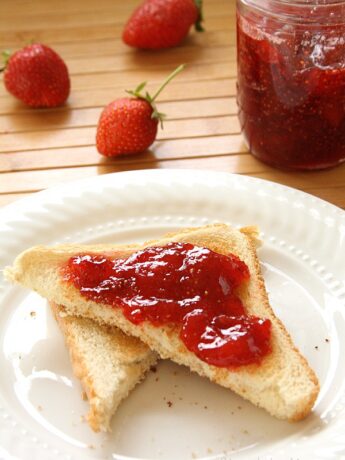 Toast with strawberry jam on white plate