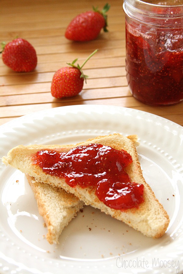 Toast with strawberry jam on white plate