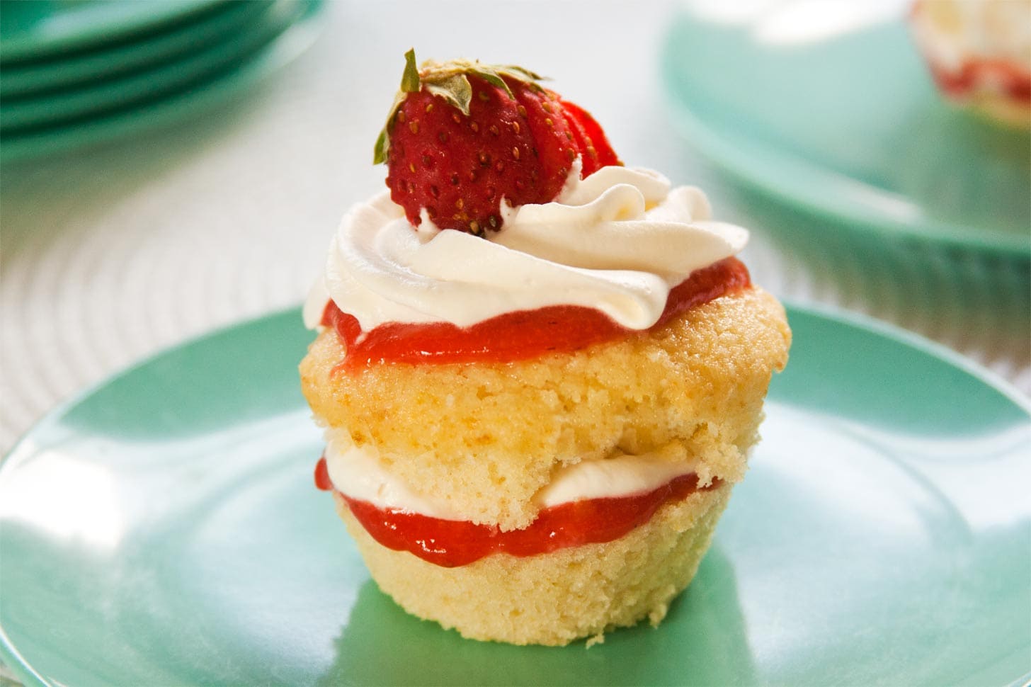 Mini sponge cake cupcakes with strawberry curd and whipped cream