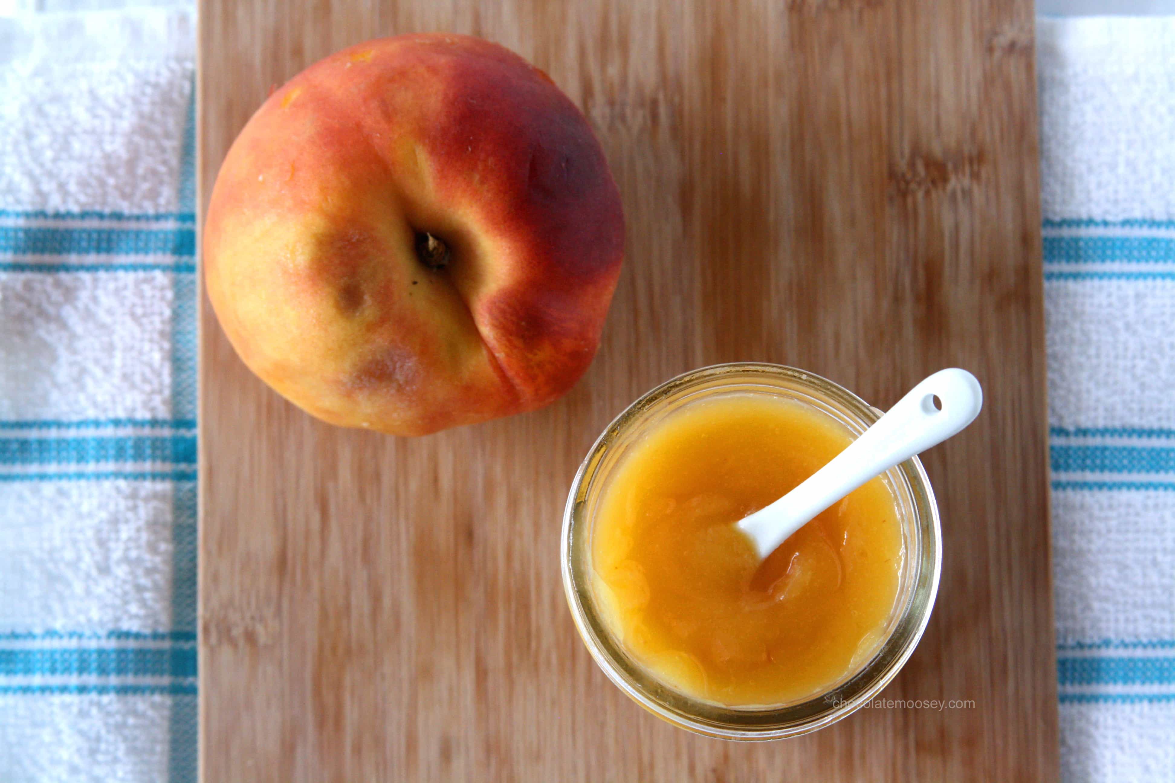 Peach Curd in a jar next to a peach