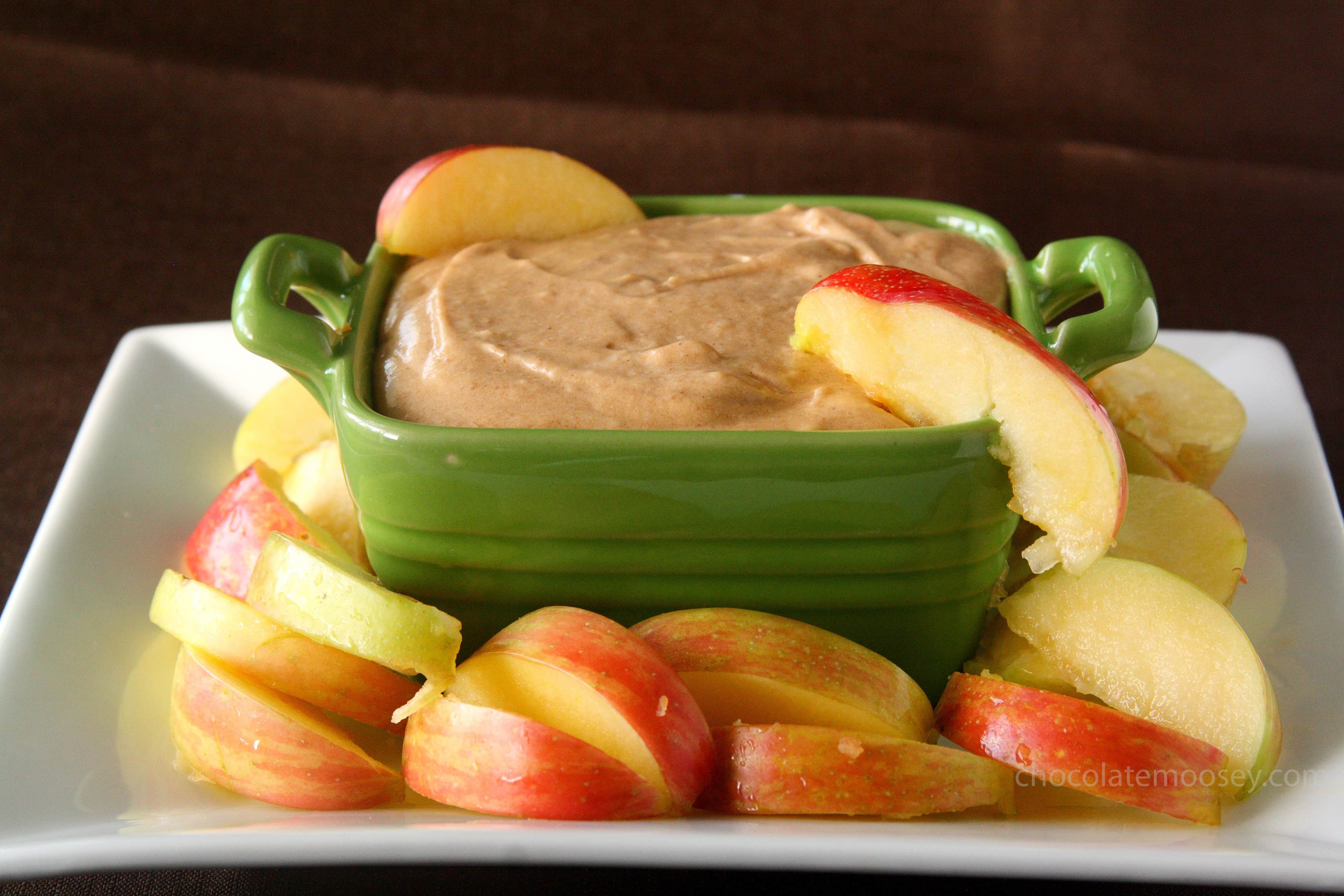 Green bowl filled with caramel apple cheesecake dip