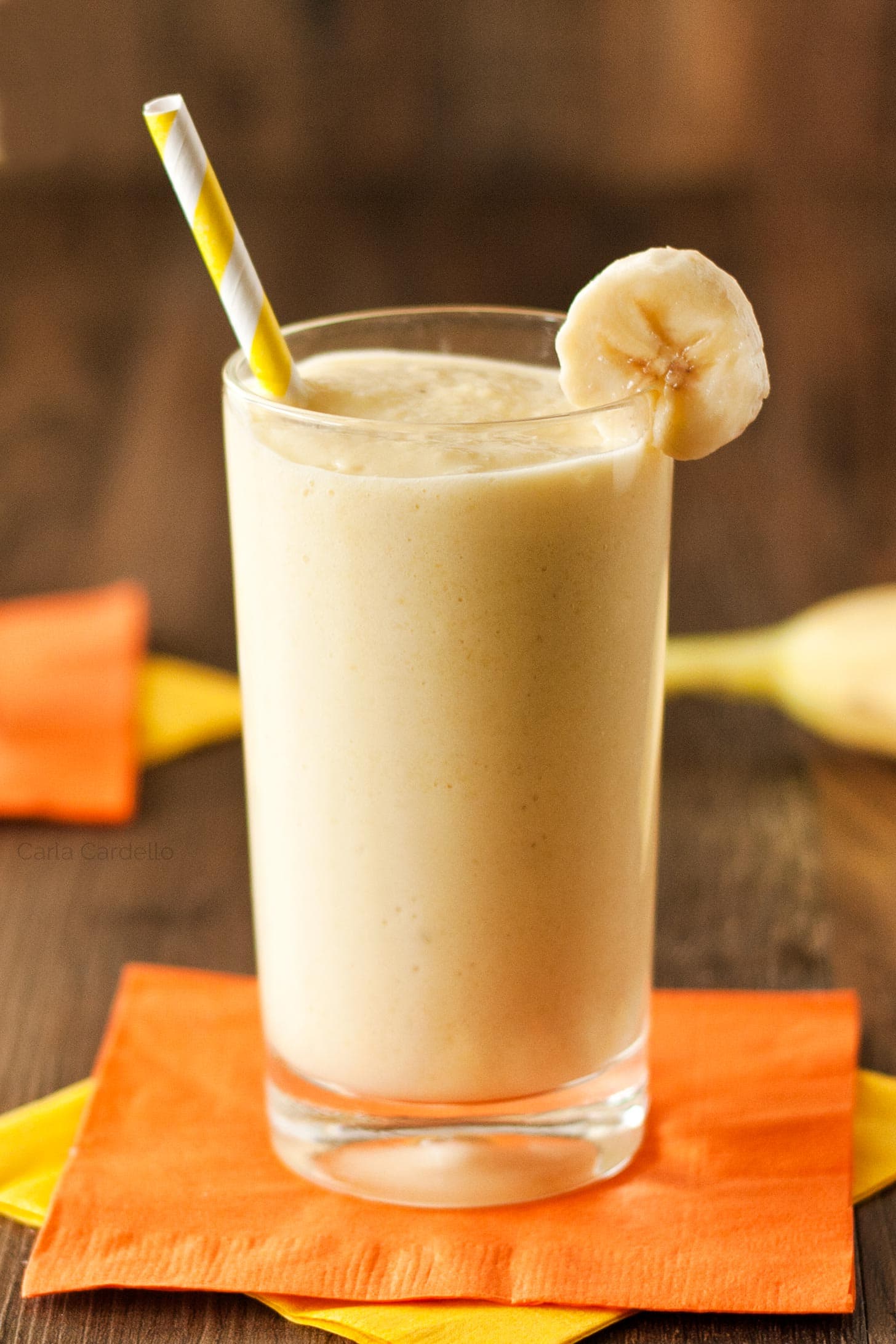 Glass of banana smoothie with yogurt with straw