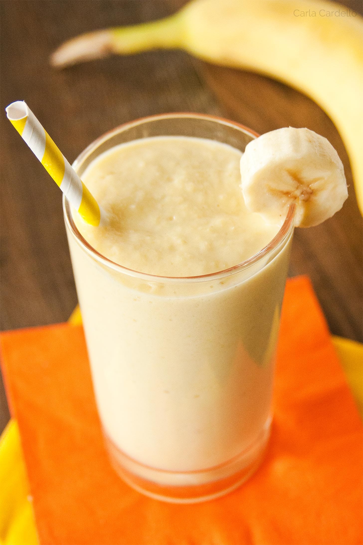 Banana Mango Smoothie in a glass with yellow straw