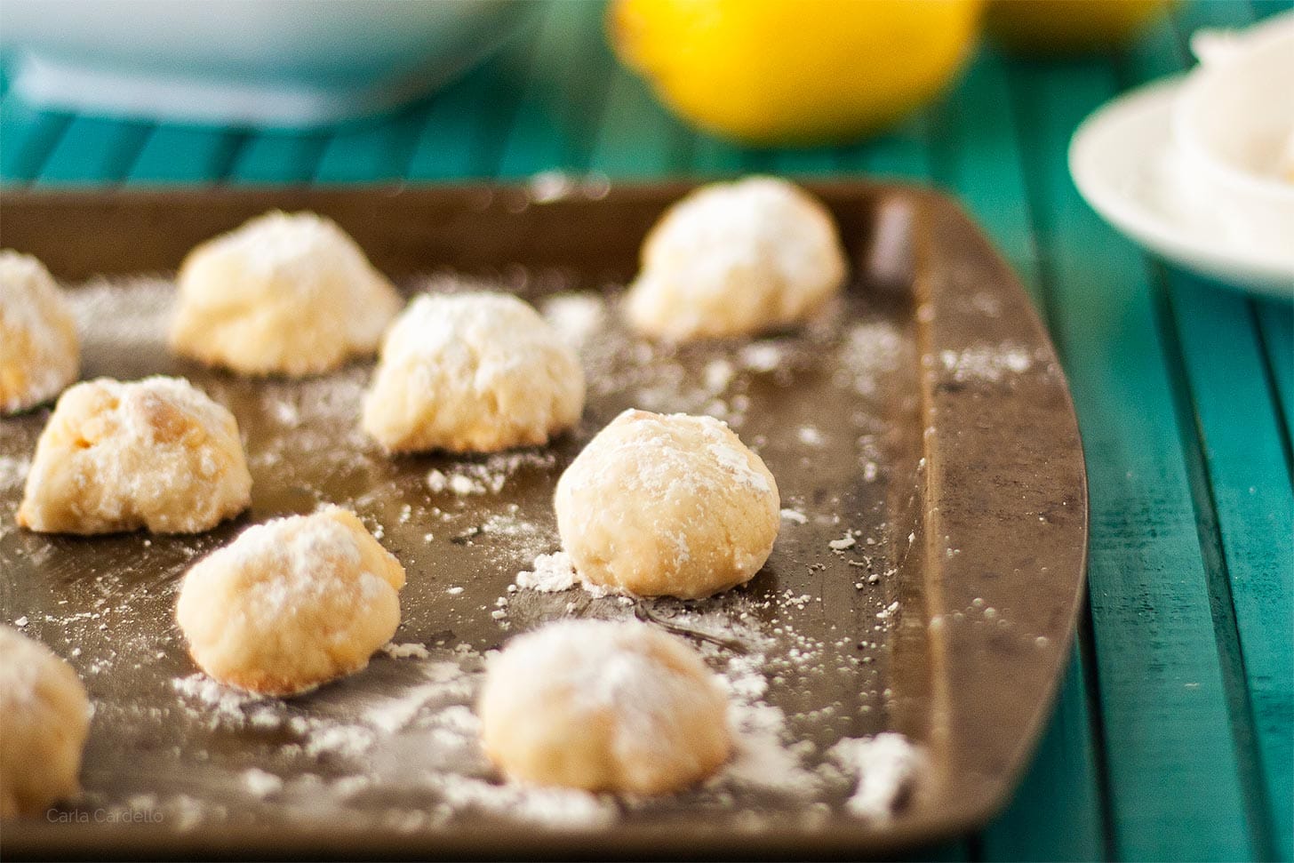 Lemon Snowball Cookies on a cookie tray with lemons