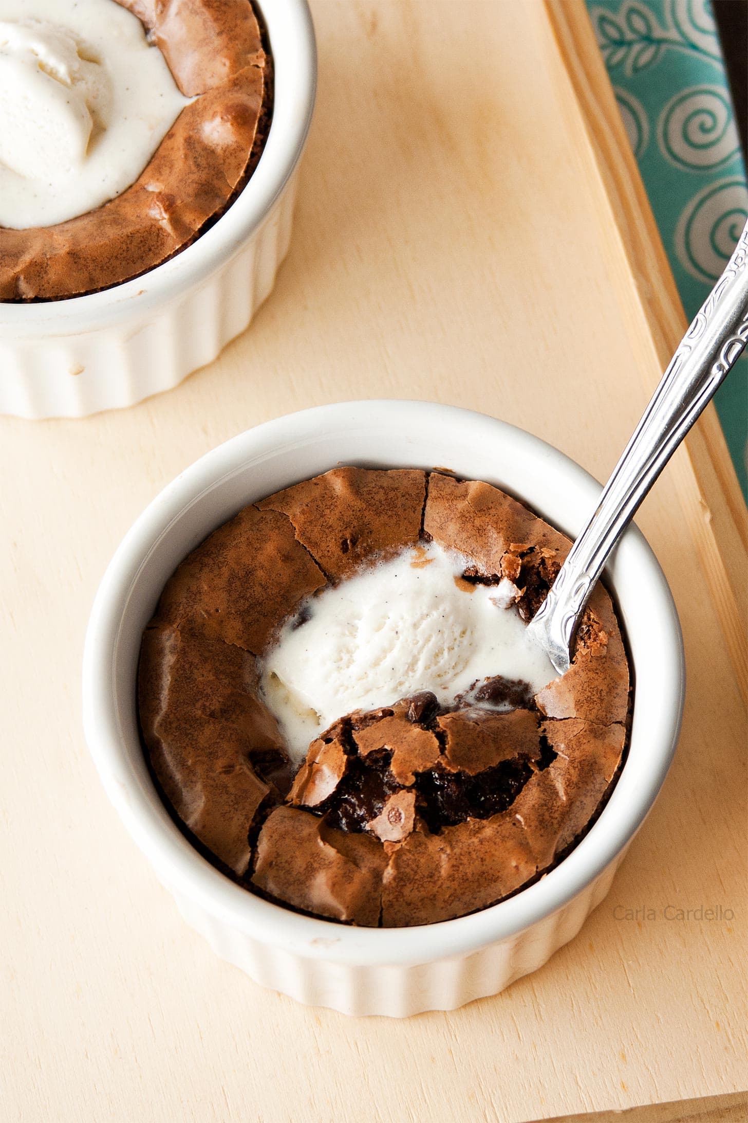 Brownie in a white ramekin with vanilla ice cream on top