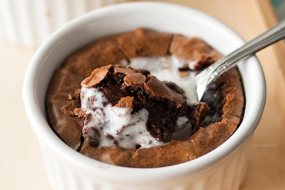 Close up of brownie in white ramekin with spoon in middle