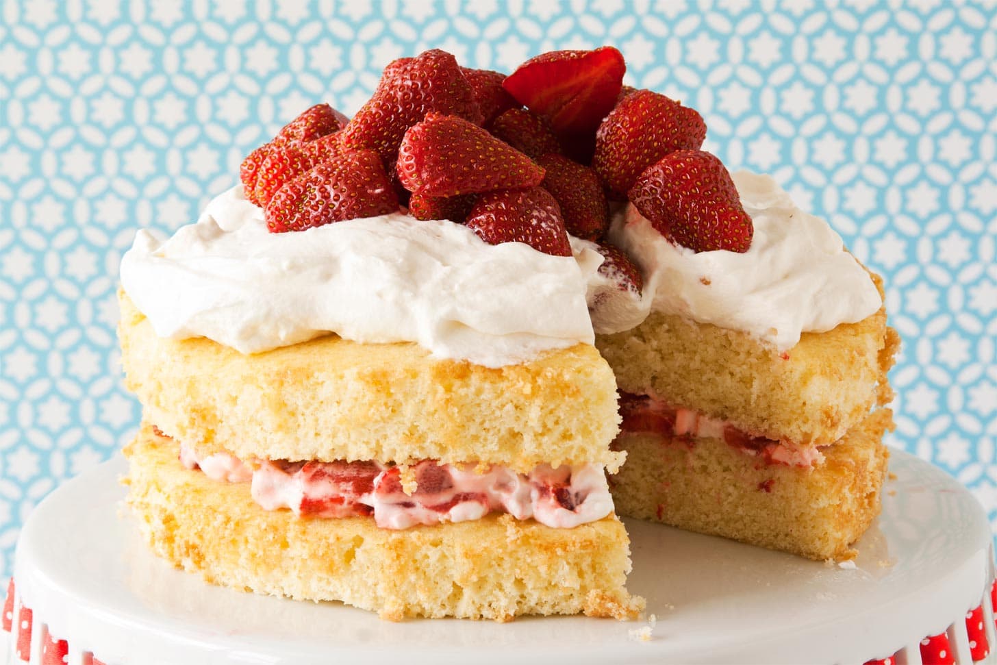 Close up of strawberry shortcake layer cake with slice missing