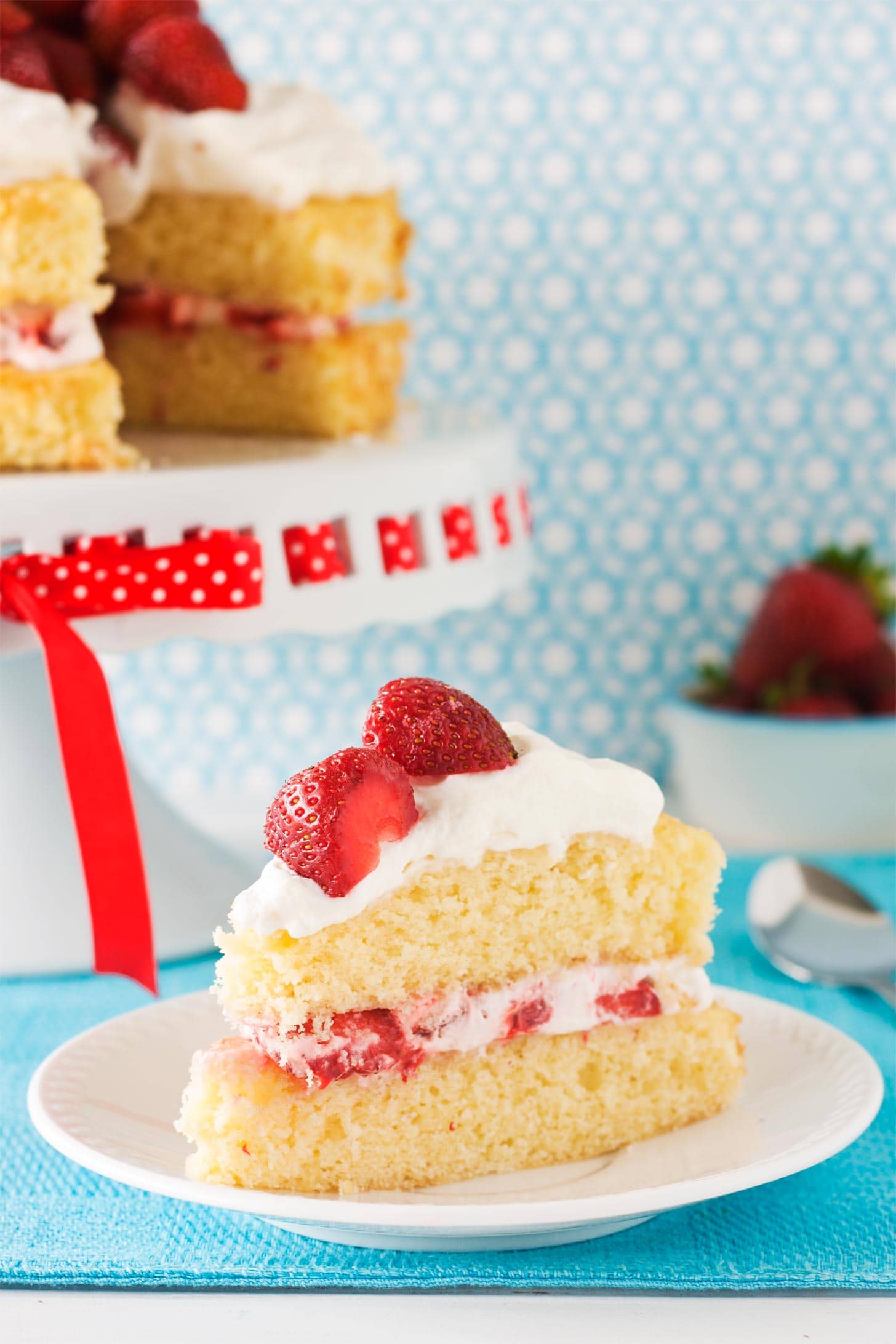 Slice of layered strawberry shortcake with whipped cream