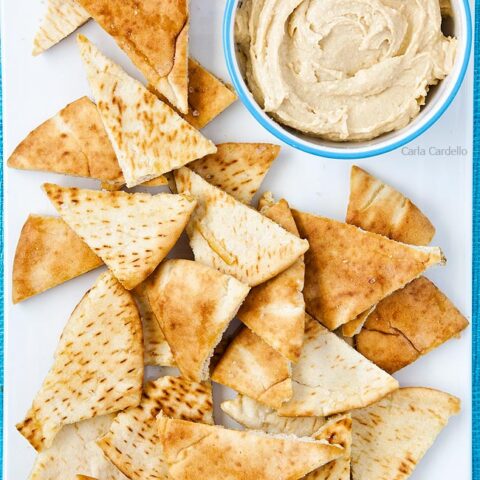 Close up of homemade pita chips on white serving platter