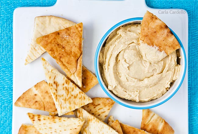 Homemade pita chips with hummus on serving platter