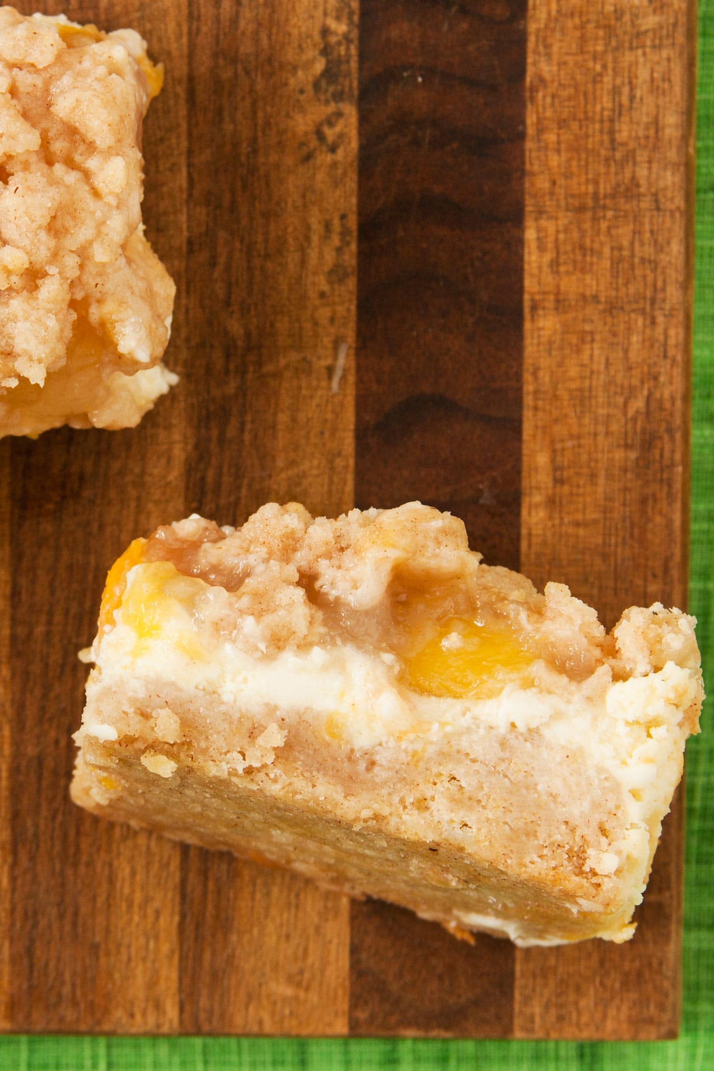 Peach Cheesecake Bars on wooden cutting board