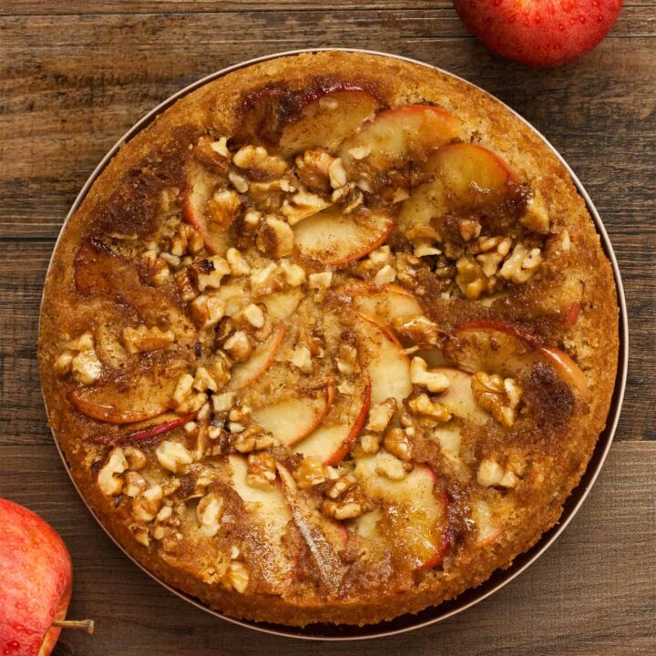 Apple Upside Down Cake with apples on wooden table