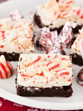 Peppermint bark brownies cut and served on a white plate