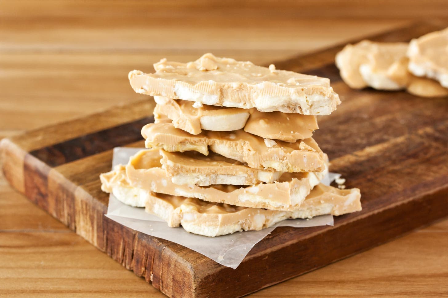 Peanut butter bark with banana stacked on cutting board