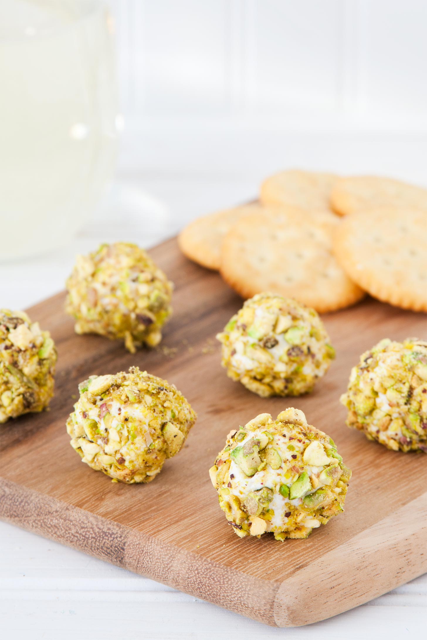 Goat cheese truffles served with wine on a cutting board