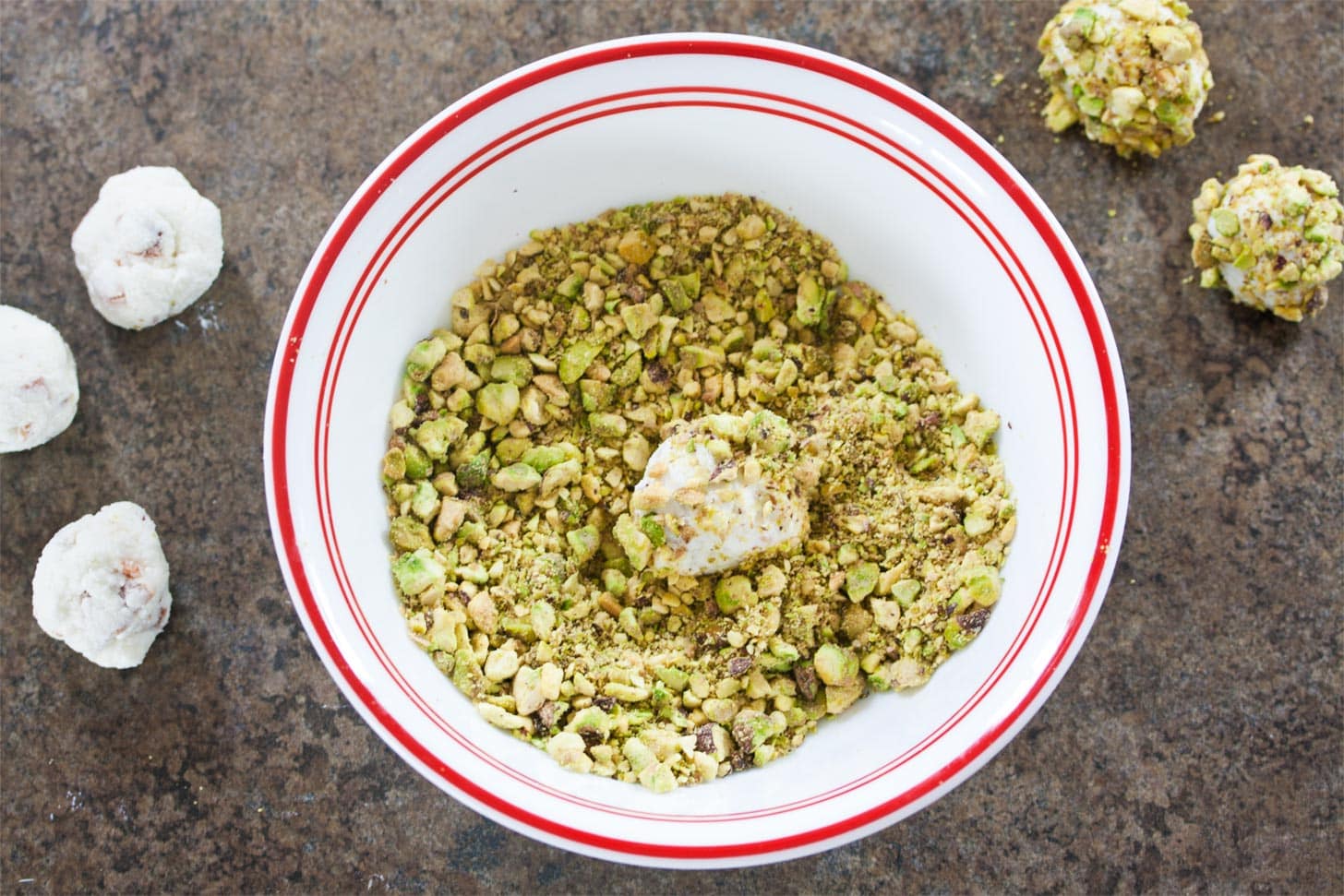 Rolling goat cheese balls into pistachios
