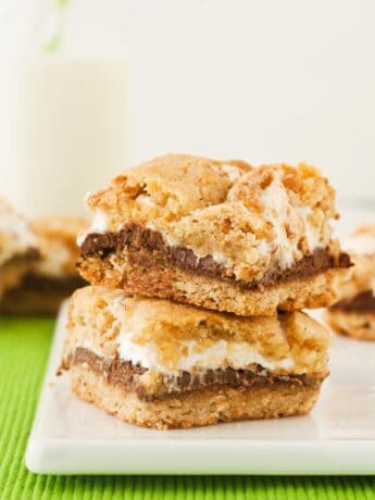 Two Smores Bars stacked on a white cutting board