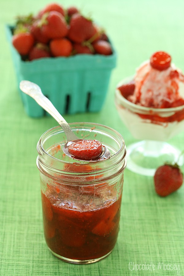 Strawberry sauce in a jar with basket of strawberries