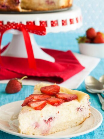 Slice of strawberry shortcake cheesecake with sponge cake crust