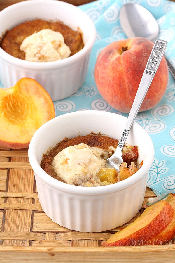 White ramekin with spoon inside peach cobbler