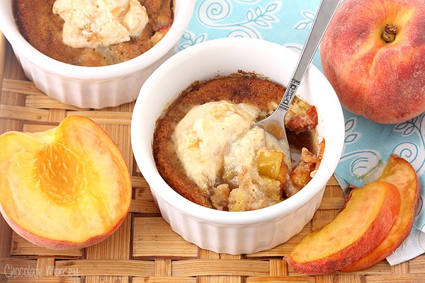 White ramekin with spoon inside peach cobbler