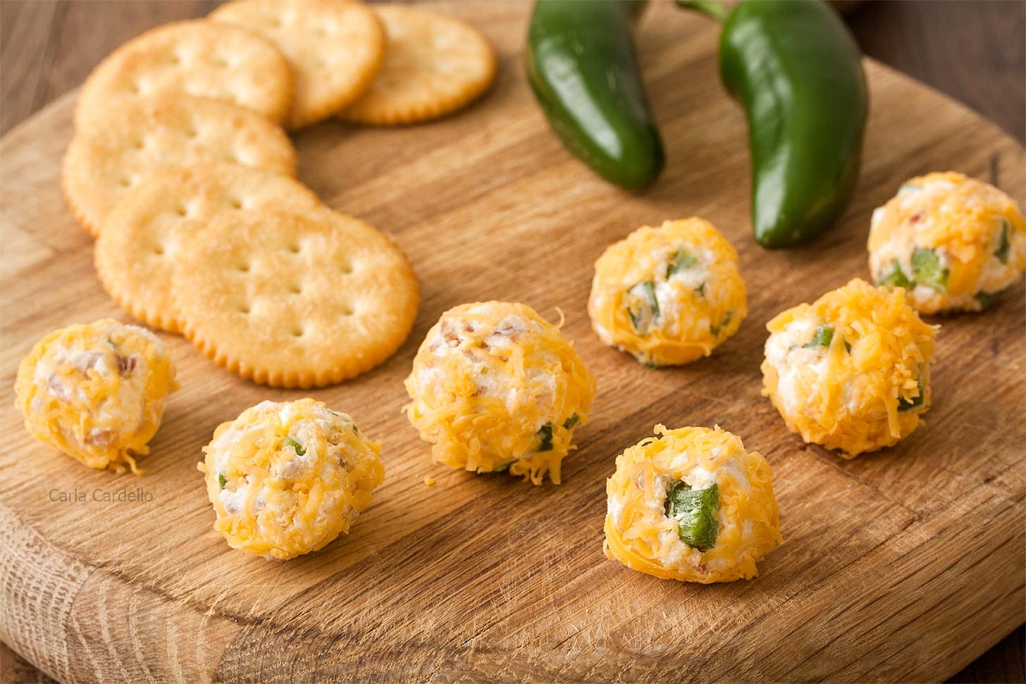 Cheese ball bites on thick wooden cutting board