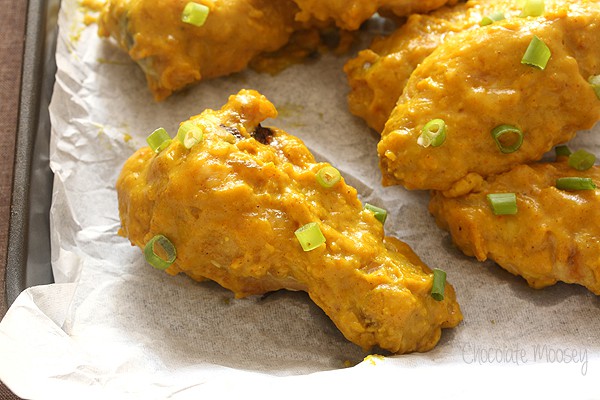 Close up of curry wing on parchment paper on cookie tray