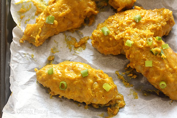 Close up of curry wing on parchment paper on cookie tray