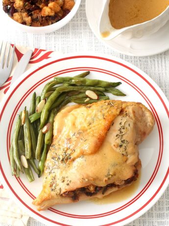 Stuffed turkey breast on plate with green beans
