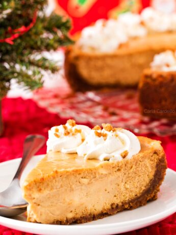 Slice of Gingerbread Cheesecake on white plate with Christmas background
