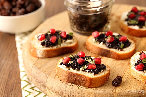 Raisin Jam and Goat Cheese Crostini with pomegranate seeds and fresh basil
