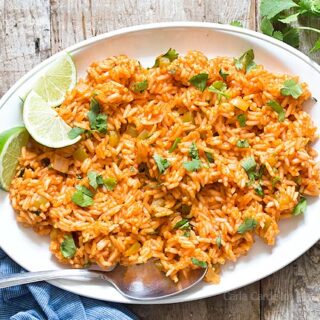 Spanish Rice on white platter with lime slices