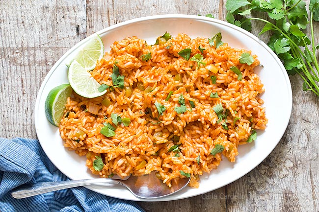 Spanish Rice on white platter with lime slices
