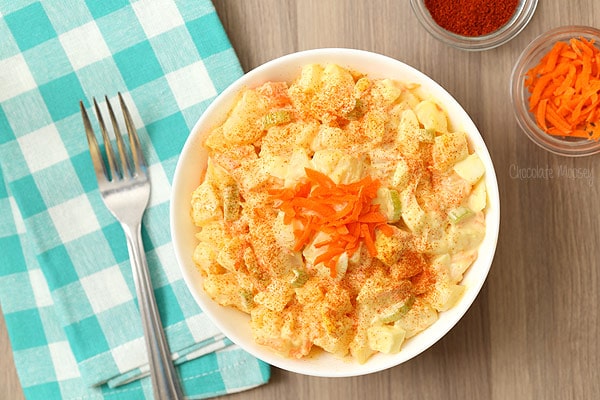 Amish potato salad in a white bowl with turquoise linen