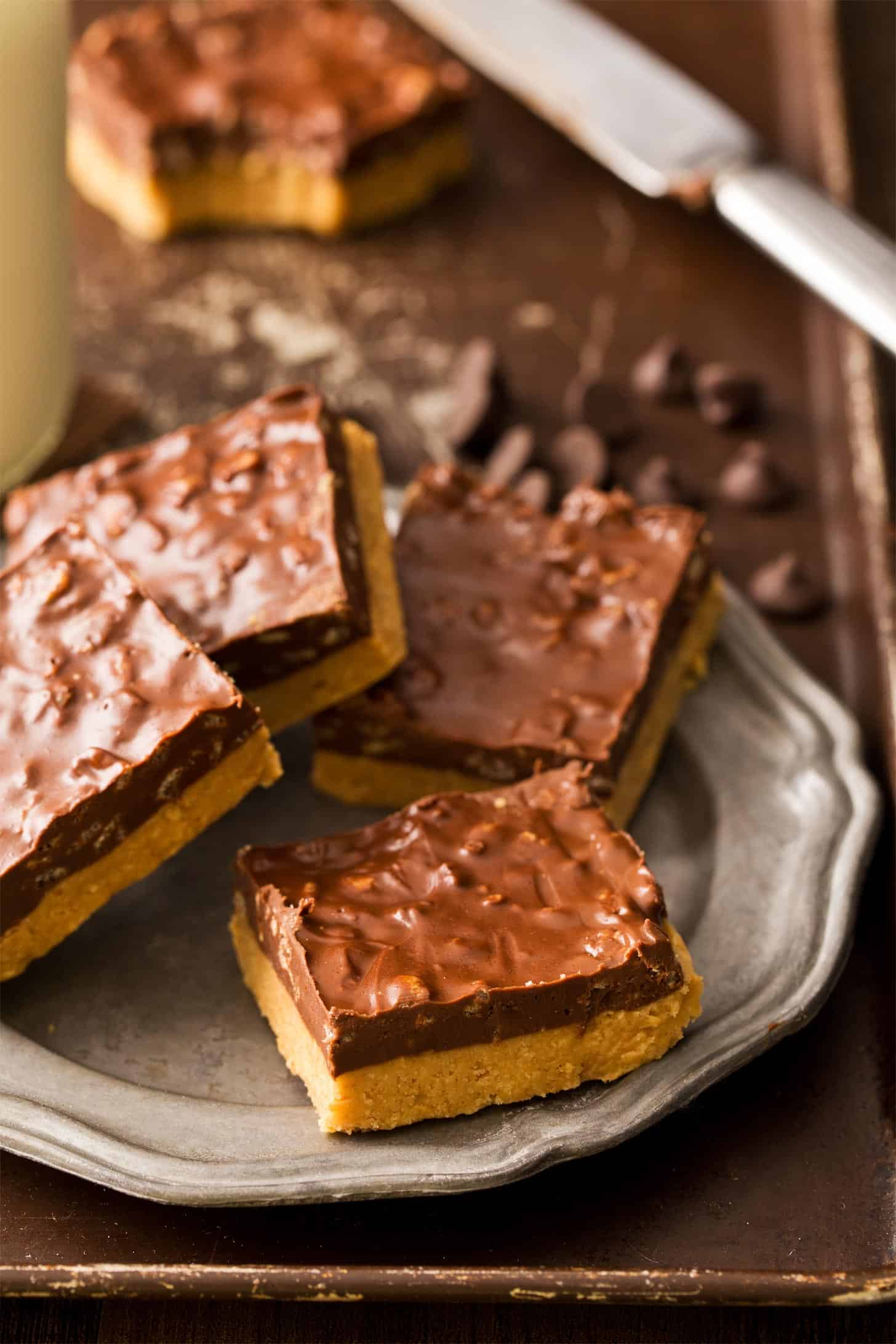 No Bake Peanut Butter Bars with Chocolate stacked on silver plate