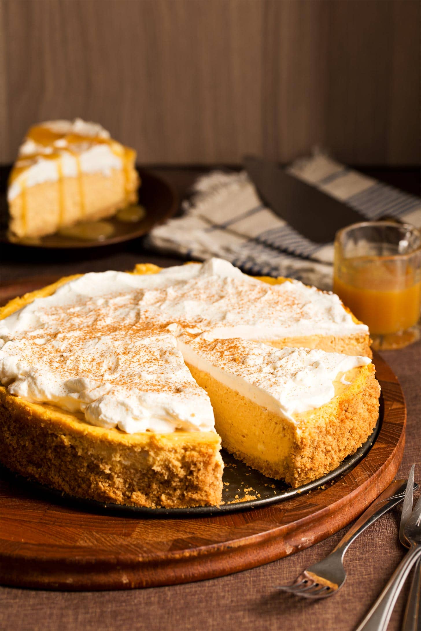 Pumpkin cheesecake cut on a round brown board