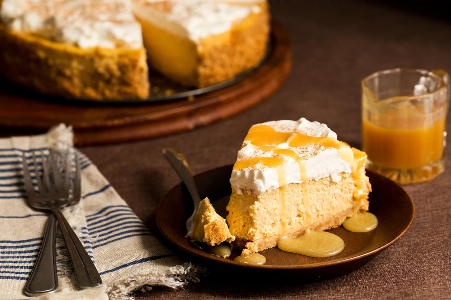 Slice of pumpkin cheesecake with caramel drizzle