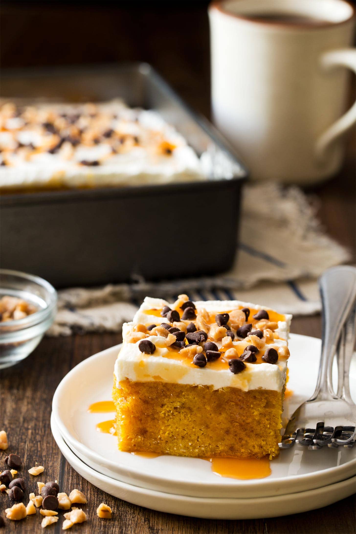 Slice of pumpkin poke cake on white plate