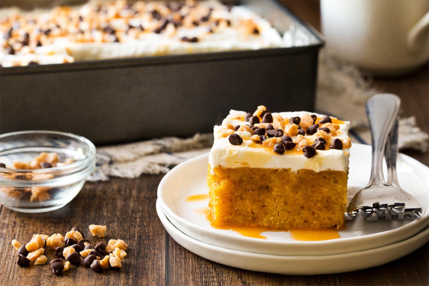 Slice of pumpkin caramel poke cake on white plate
