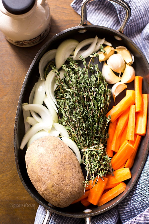 Ingredients for roasted chicken quarters in a roasting pan