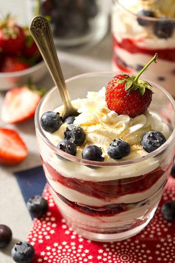 Beat the heat this summer with these red, white, and blue No Bake Mixed Berry Cheesecake Parfaits with fresh strawberries and blueberries. Made with homemade whipped cream (no Cool Whip)