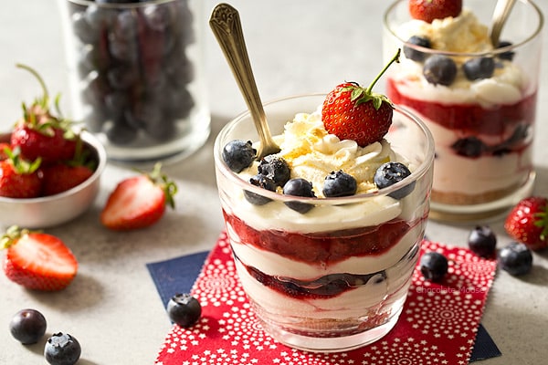 Beat the heat this summer with these red, white, and blue No Bake Mixed Berry Cheesecake Parfaits with fresh strawberries and blueberries. Made with homemade whipped cream (no Cool Whip)