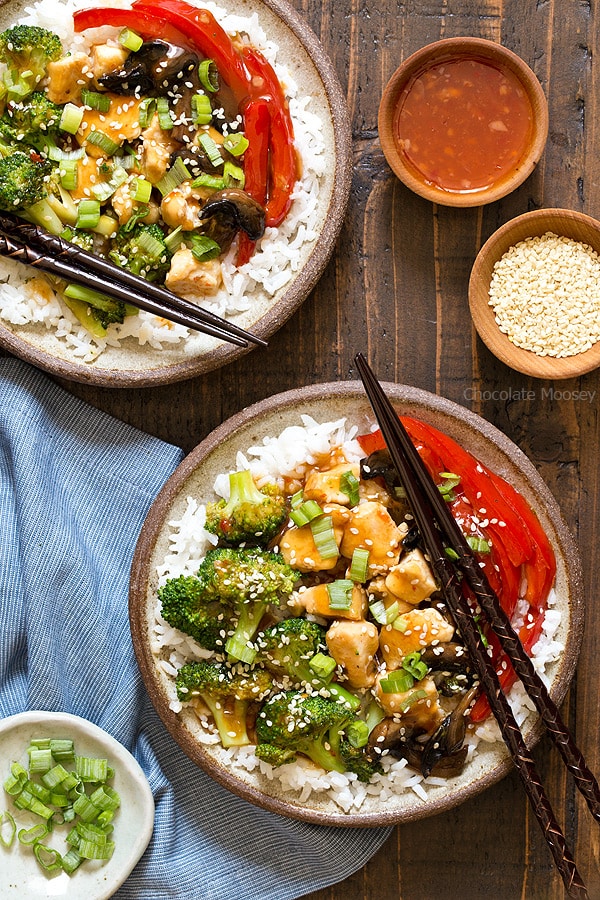 A cheaper and healthier alternative to Chinese takeout - homemade General Tso's Sweet Chili Chicken Rice Bowls with broccoli, red bell pepper, and mushrooms.