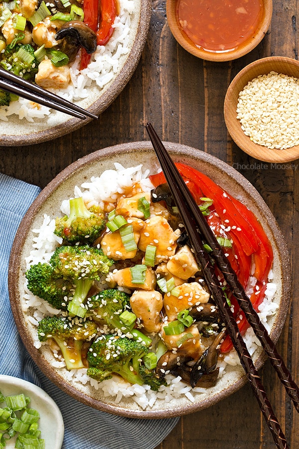 A cheaper and healthier alternative to Chinese takeout - homemade General Tso's Sweet Chili Chicken Rice Bowls with broccoli, red bell pepper, and mushrooms.