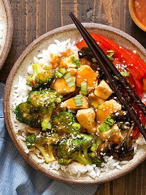 A cheaper and healthier alternative to Chinese takeout - homemade General Tso's Sweet Chili Chicken Rice Bowls with broccoli, red bell pepper, and mushrooms.